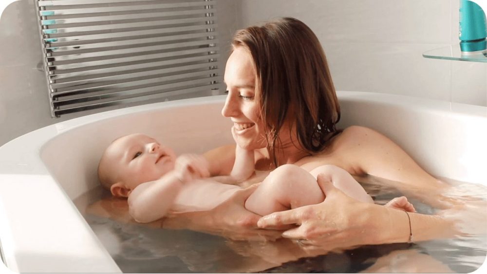 Papa accompagne bébé dans l'eau piscine éveil aquatique